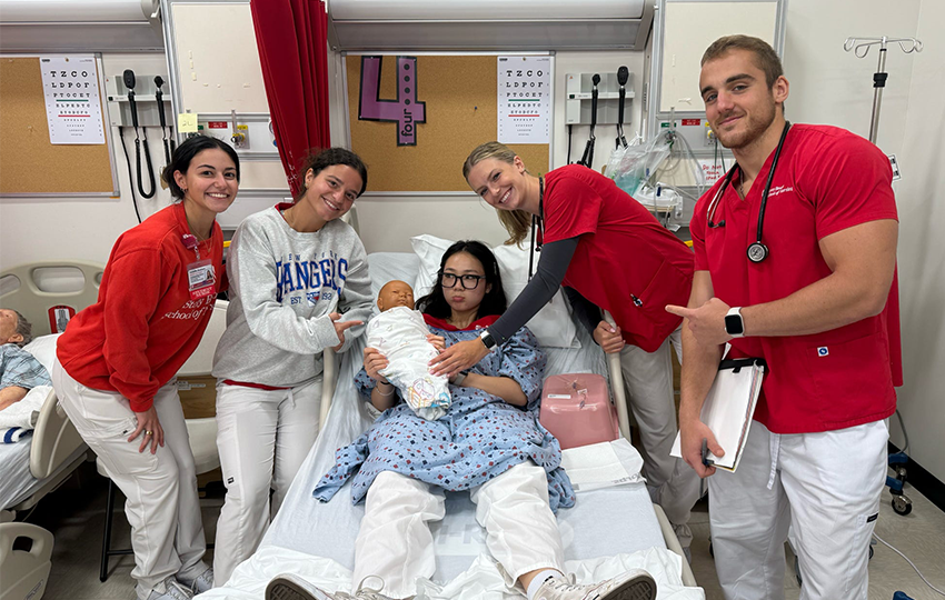 A group of nursing students posing for a photo in the NEXUS Simulation Center.
