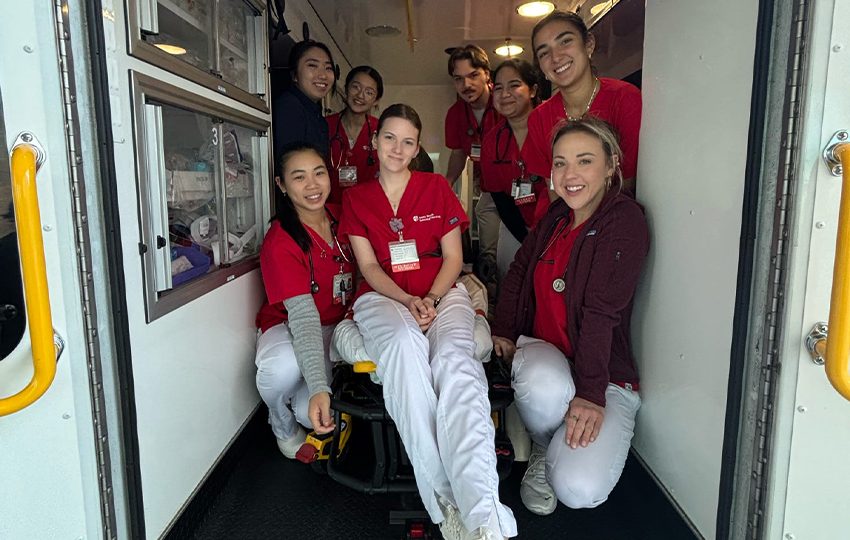 Nursing students posing in the back of an ambulance. 